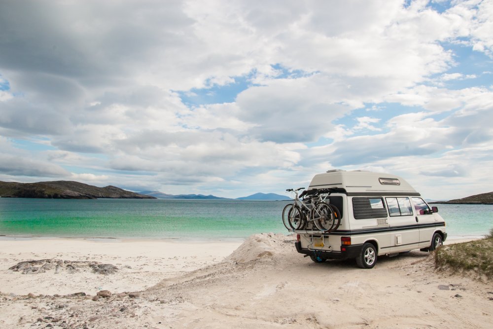 A campervan parked right by the sea