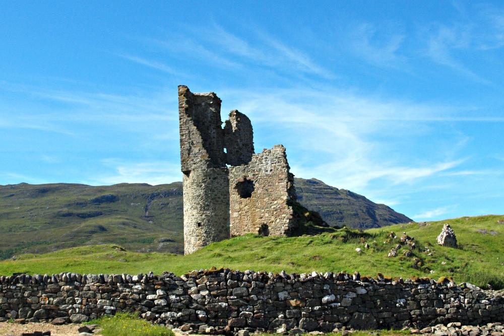 The remains of a ruined Scottish castle near a mountain range
